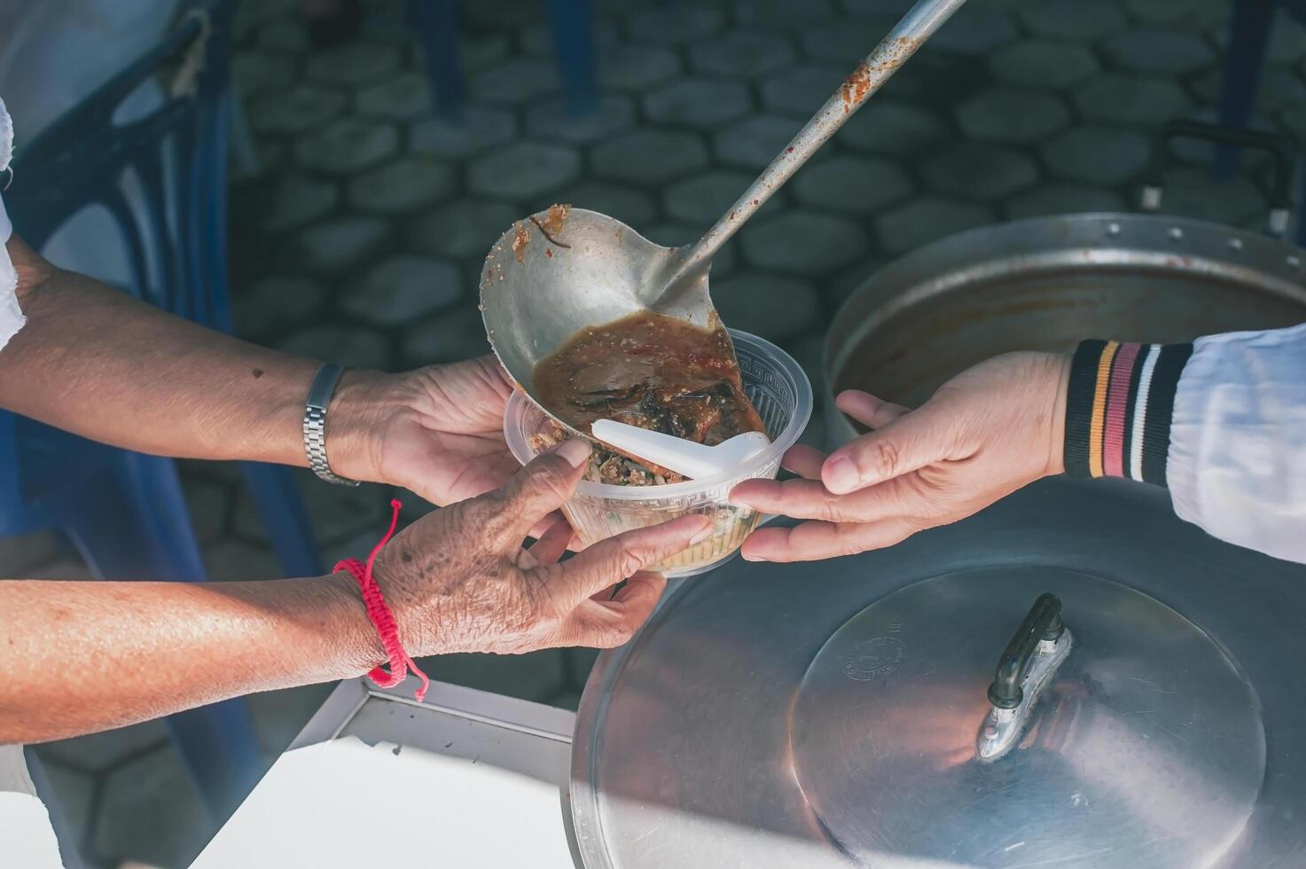 Volunteers give food to the poor, share free food to help beggars. food donation concept photo