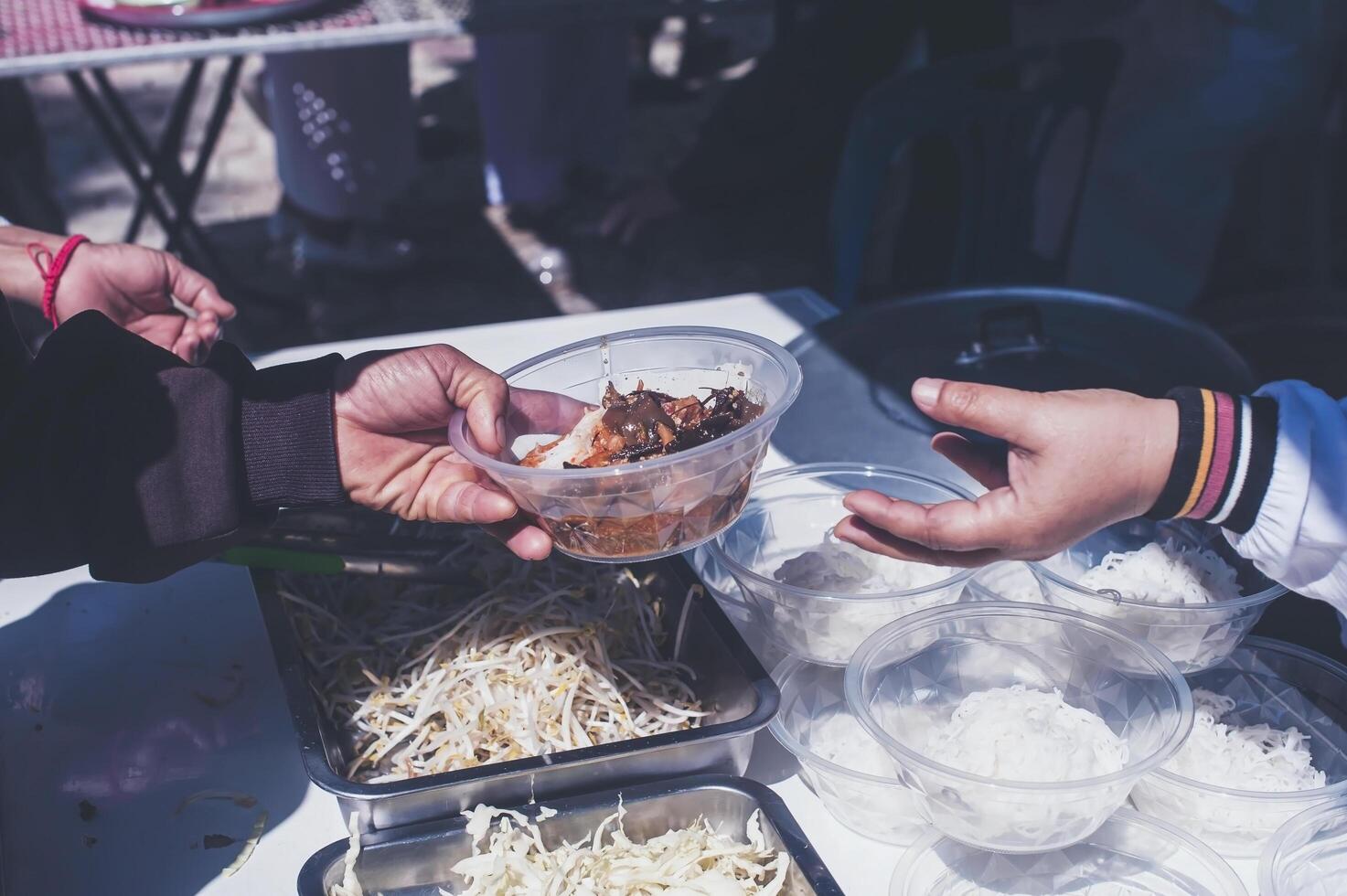 Volunteers serving hot meals to hungry migrants humanitarian aid concept. photo