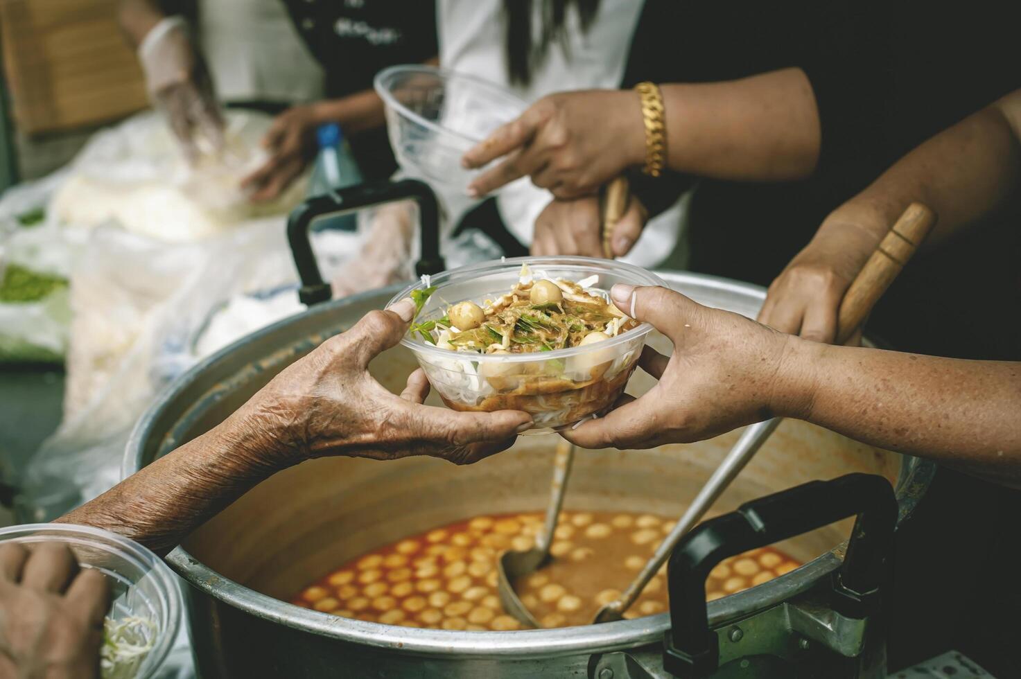 The help of volunteers helps to donate free food to the starving people. photo