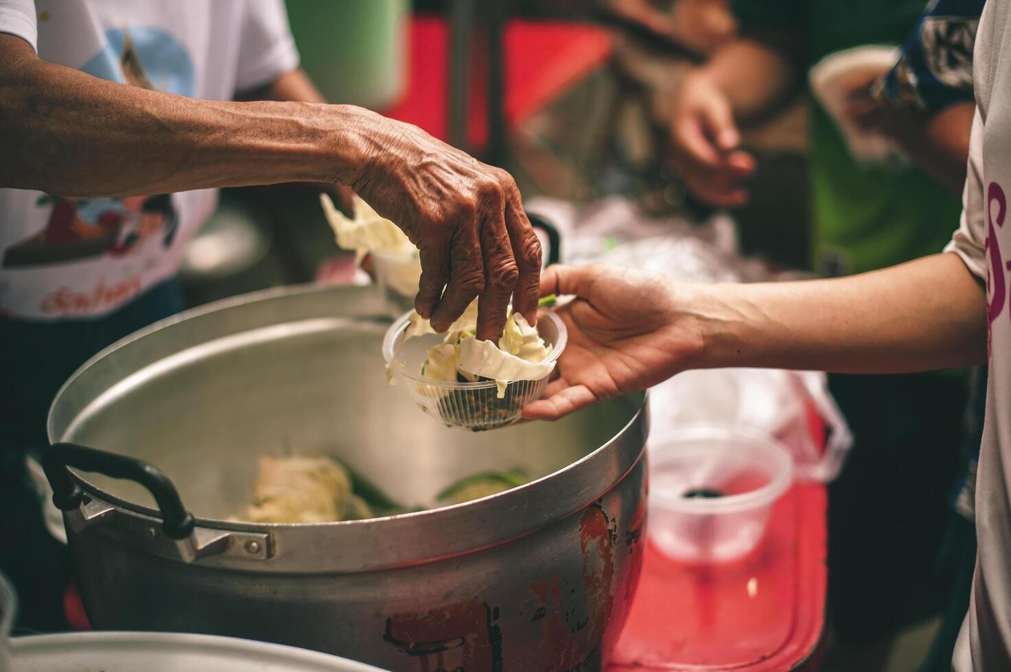 Volunteers are giving free food to help the hungry poor concept of food sharing photo
