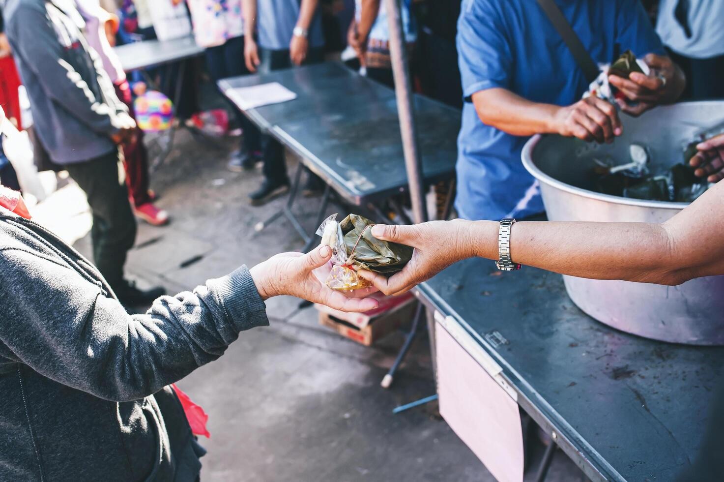 Volunteers are giving free food to help the hungry poor concept of food sharing photo