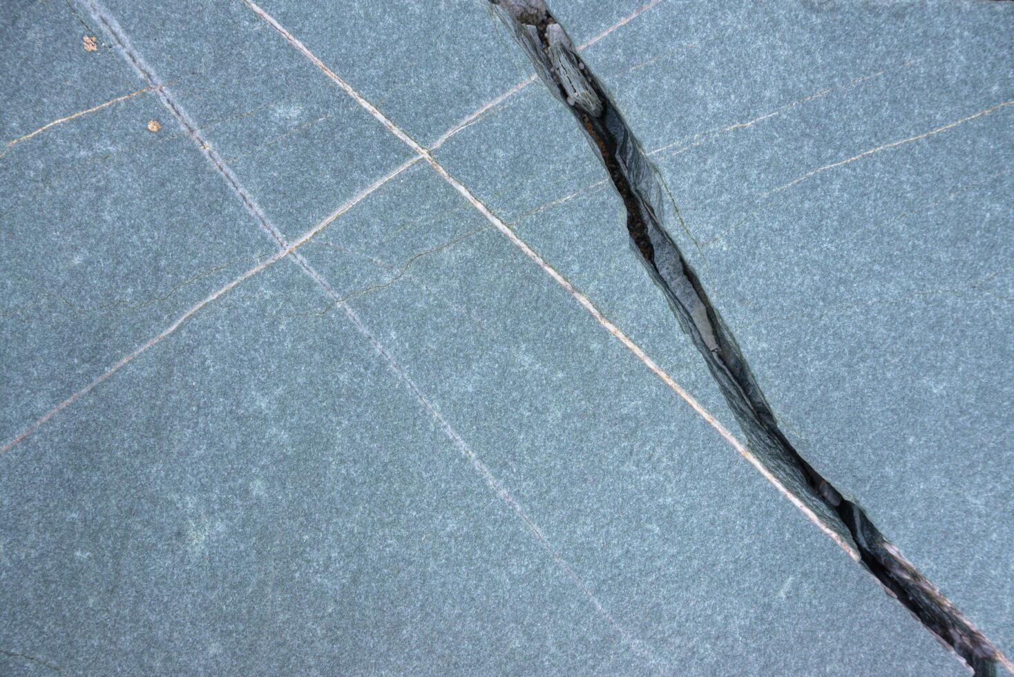Cracks and white lines of intrusion in marine slate photo