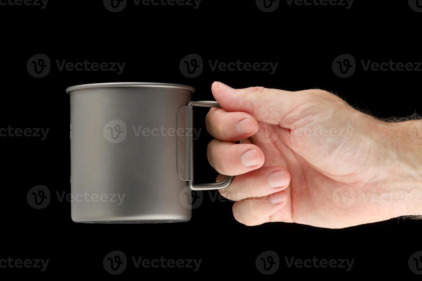 Titanium cup in hand on black photo