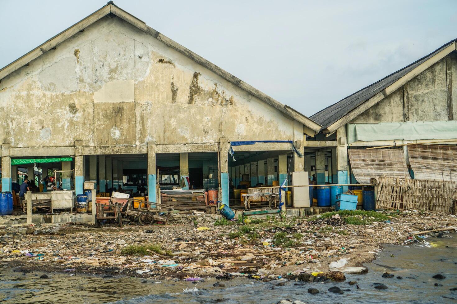 Jepara, Central Java, April 7, 2024 - The building where the fish auction is located is starting to erode with age, with rubbish strewn along the side of the building. photo