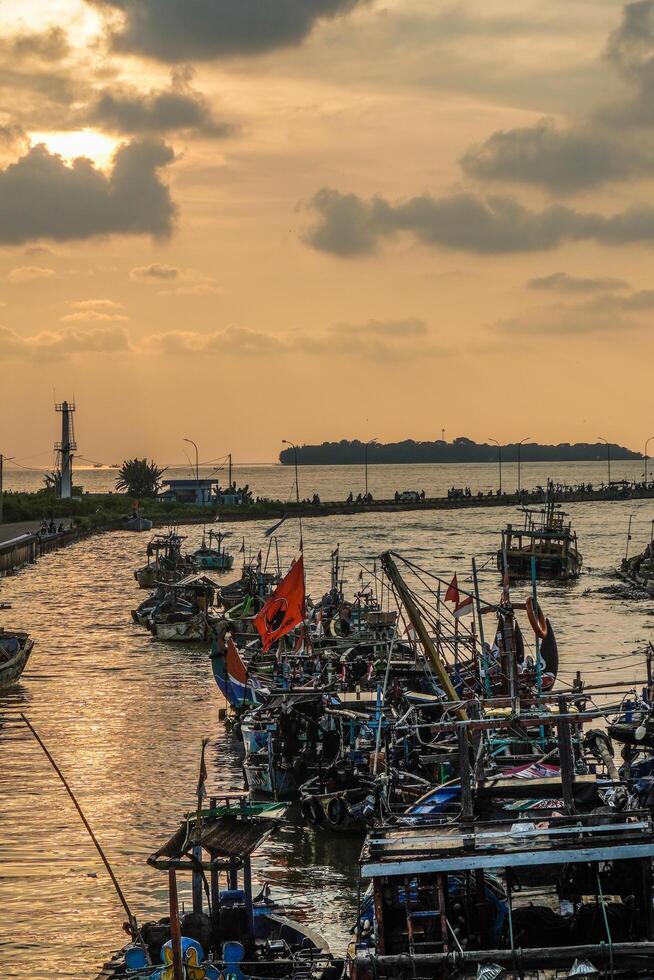 Jepara, Central Java, April 7, 2024 - Jepara fishing boats parked in a crowded harbor against the backdrop of the evening sky with empty space for advertising photo