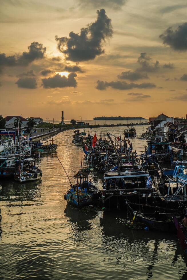 jepara, central Java, abril 7, 2024 - jepara pescar barcos estacionado en un concurrido puerto en contra el fondo de el noche cielo con vacío espacio para publicidad foto