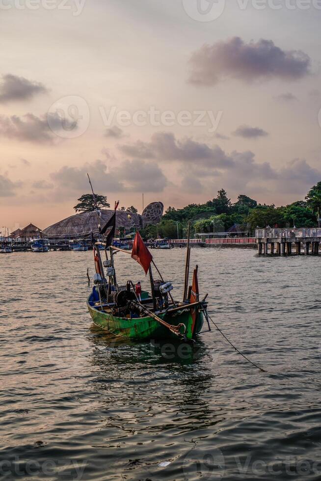 Fishing boats leaning on the seashore with the Kartini Beach tourism in Jepara, Central Java in the background. photo