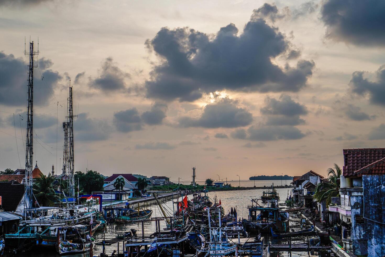 Jepara, Central Java, April 7, 2024 - Jepara fishing boats parked in a crowded harbor against the backdrop of the evening sky with empty space for advertising photo
