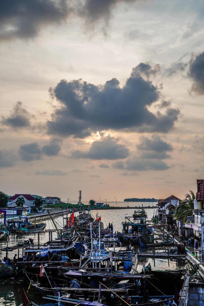 Jepara, Central Java, April 7, 2024 - Jepara fishing boats parked in a crowded harbor against the backdrop of the evening sky with empty space for advertising photo