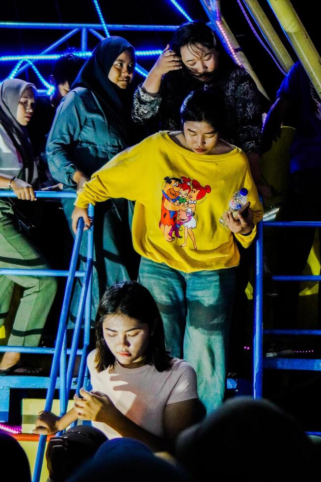 Indramayu, West Java, April 20, 2024 - people queuing to get off the fairgrounds in Indramayu at night. photo