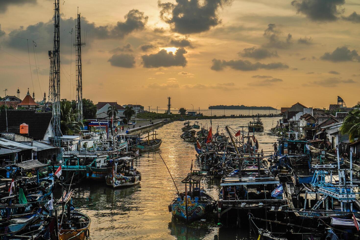 Jepara, Central Java, April 7, 2024 - Jepara fishing boats parked in a crowded harbor against the backdrop of the evening sky with empty space for advertising photo