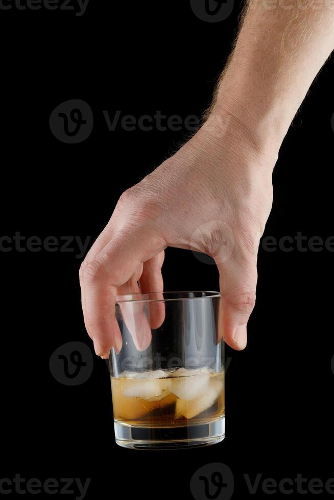 whisky con hielo en un vaso en mano. foto