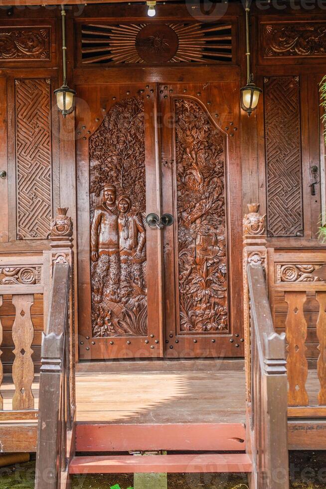 The front view of a classic wooden house, full of distinctive carvings with Javanese Indonesian nuances. photo