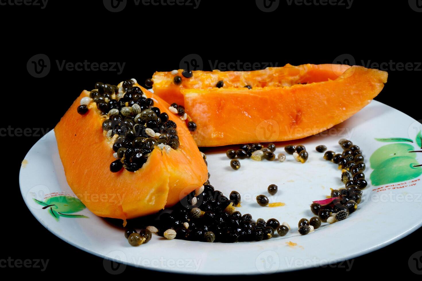 close up view of papaya fruit isolated on plate on black background. photo