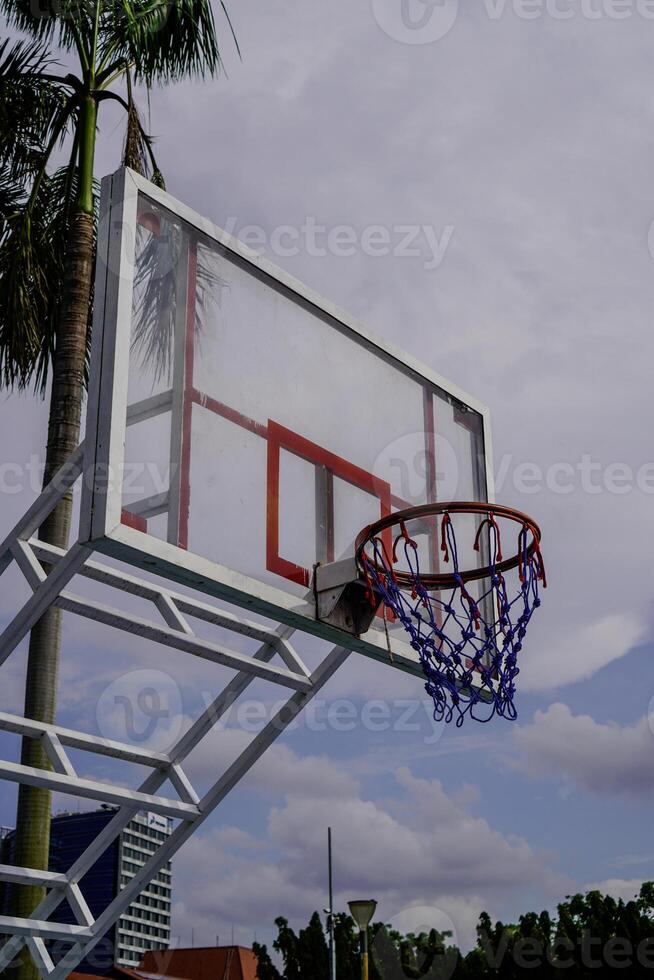 Close-up view of a basketball basket against a cloudy sky background. photo