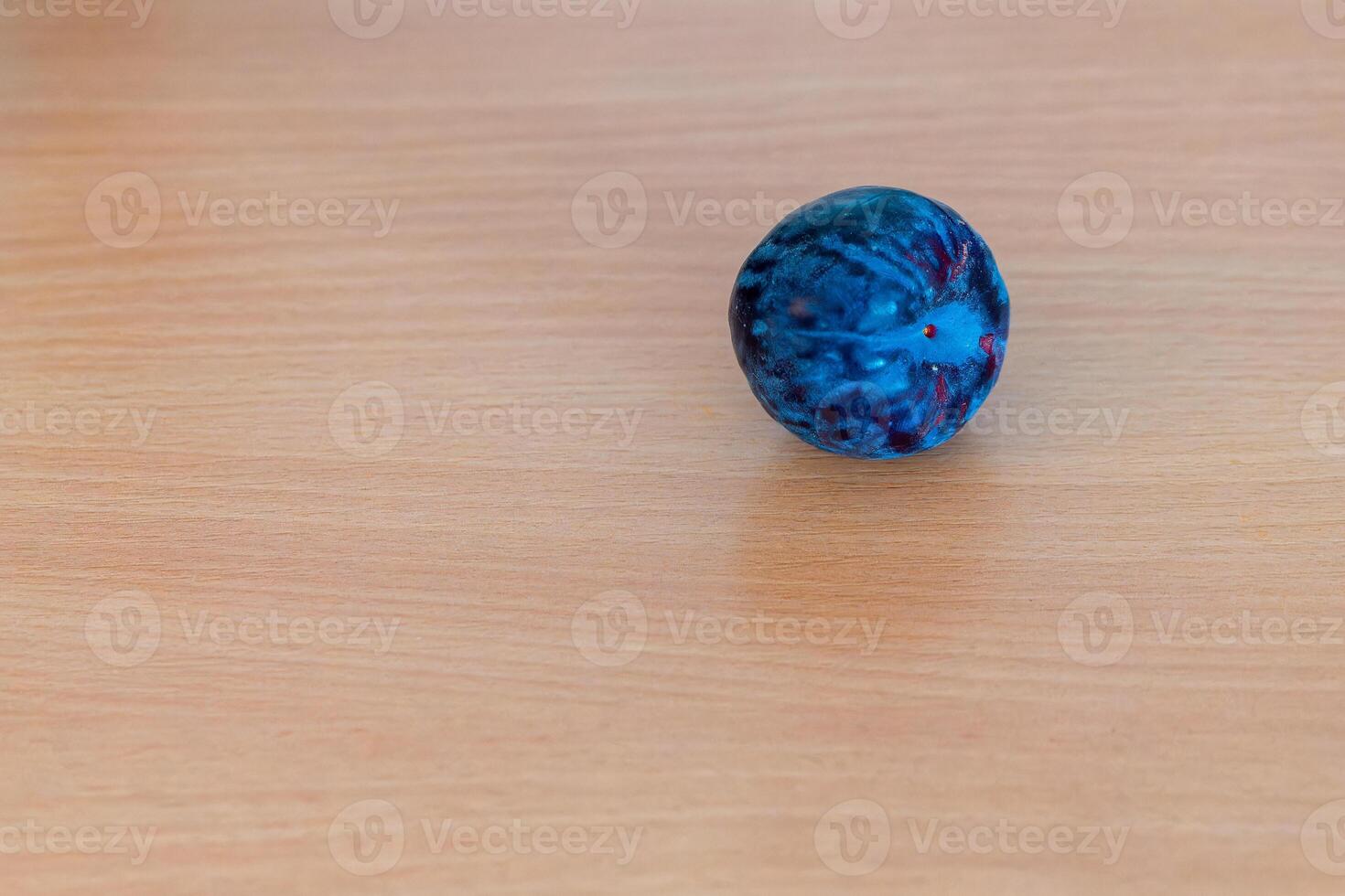 single plum on a wooden table photo