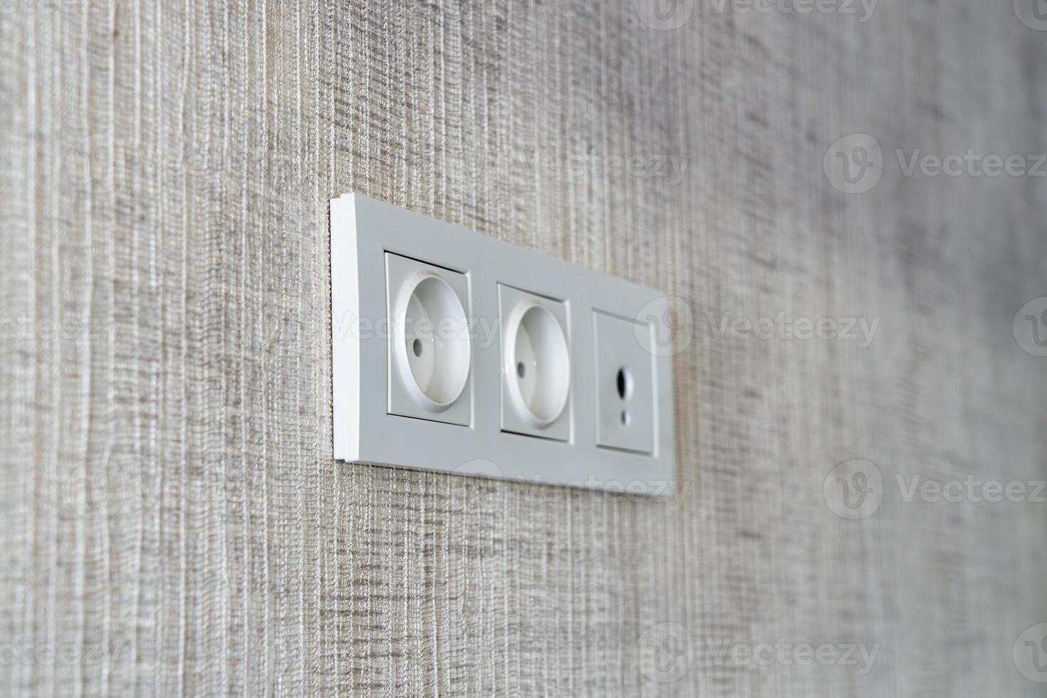 Plastic panel with electrical sockets and cable connectors on the wall. photo