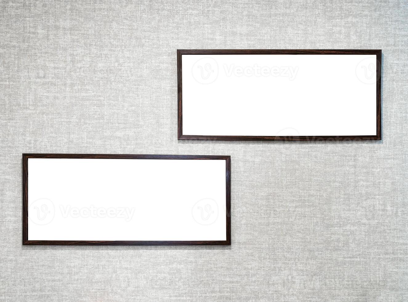Two picture frames with copy space for text hanging on the wall with wallpaper. Mockup for design. photo