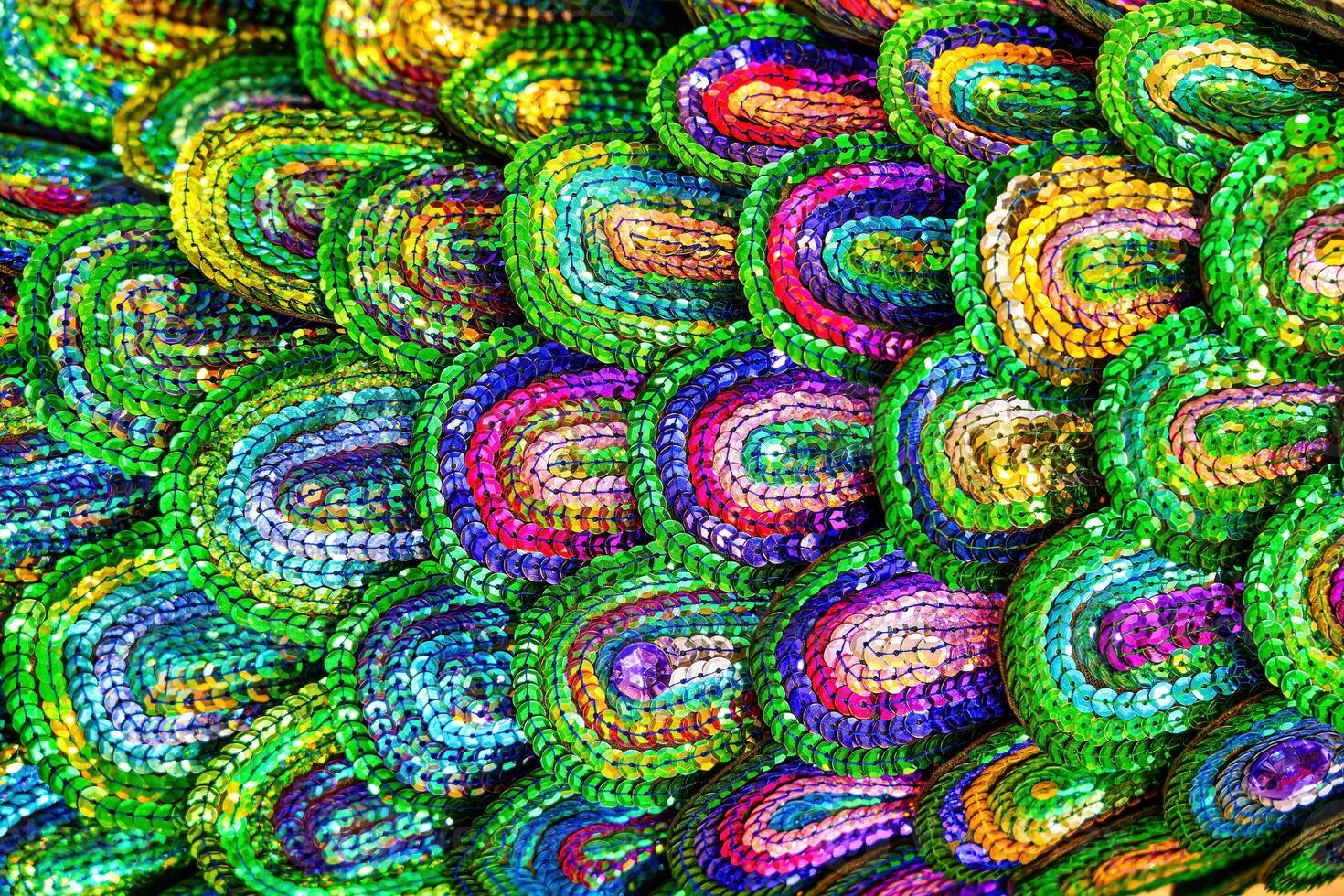 Beautiful multi-colored sequins shimmering in the light in the form of a peacock tail. Abstract background. photo