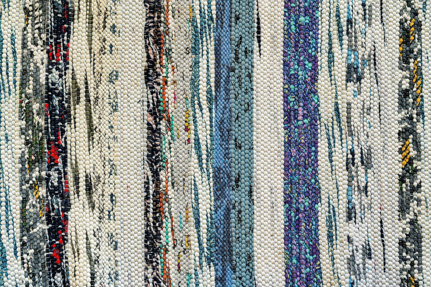 Texture of a multi-colored wicker floor carpet close-up. Abstract background. photo