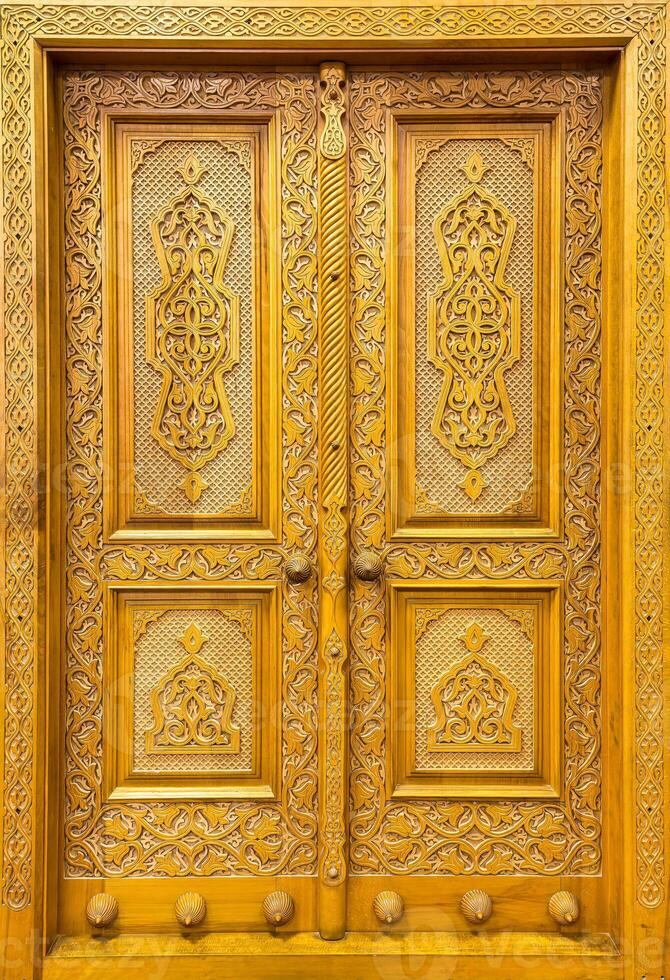 Carved wooden doors with patterns and mosaics. Abstract background. photo