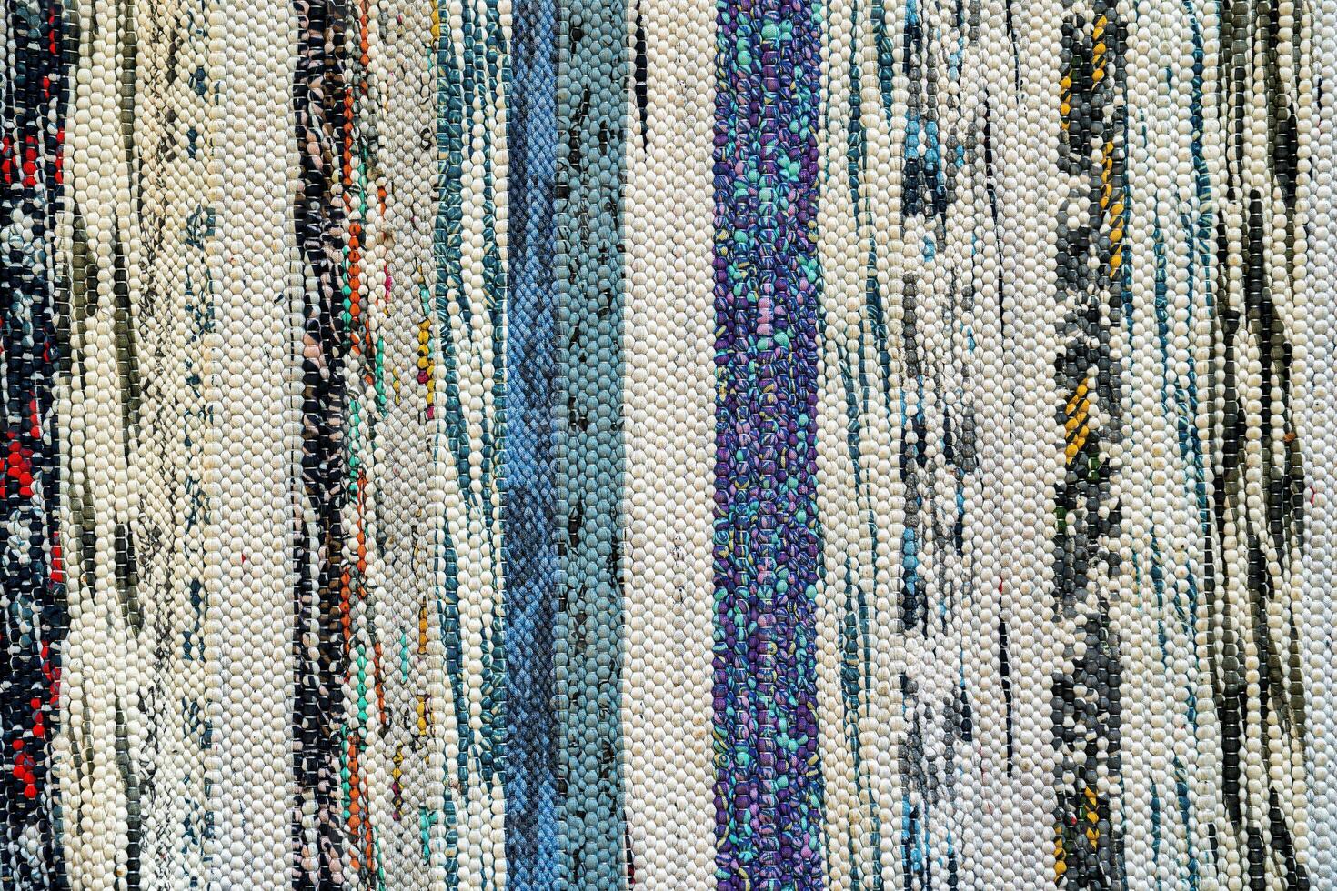 Texture of a multi-colored wicker floor carpet close-up. Abstract background. photo