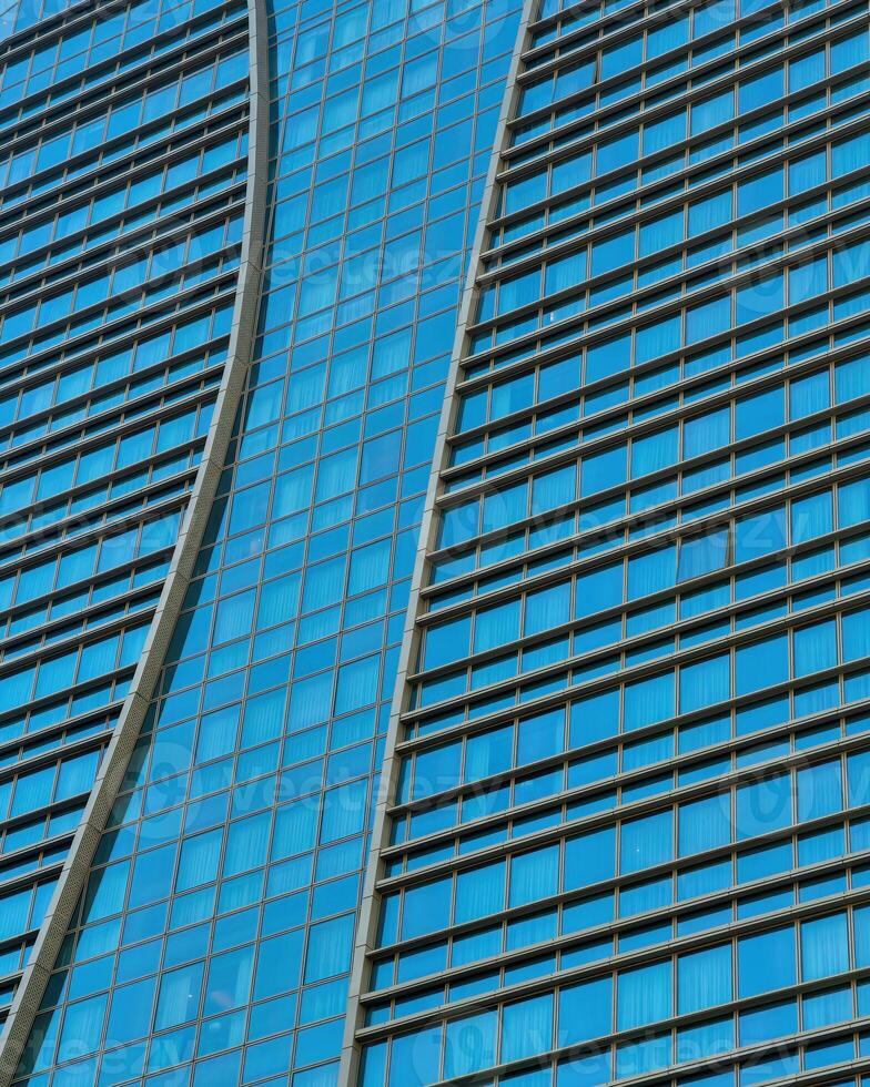 Fragment of a modern office building. Abstract geometric background. Part of a skyscraper with glass windows. photo