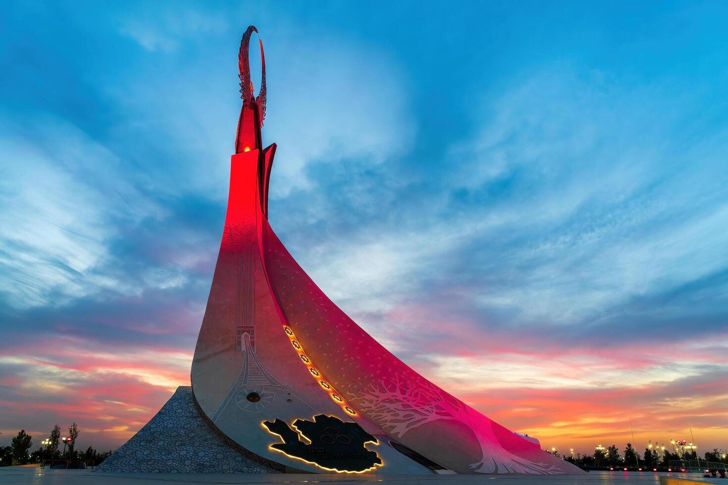 UZBEKISTAN, TASHKENT - SEPTEMBER 15, 2023 Monument of Independence in the form of a stele with a Humo bird on a twilight with dramatic cliods in the New Uzbekistan park. photo