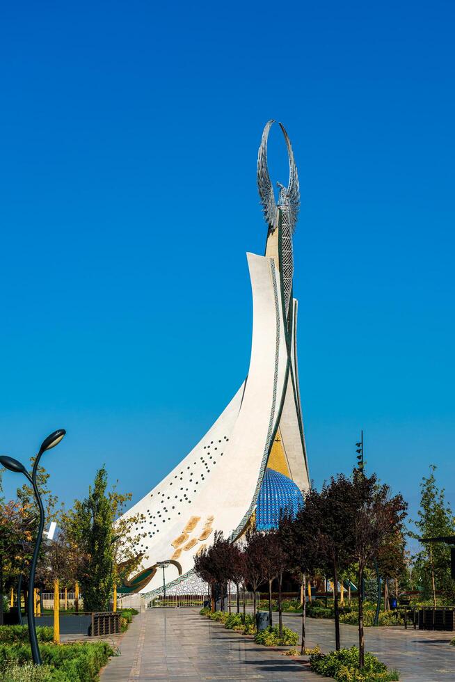 UZBEKISTAN, TASHKENT - SEPTEMBER 15, 2023 Monument of Independence in the form of a stele with a Humo bird on a daytime in the New Uzbekistan park in summer. photo