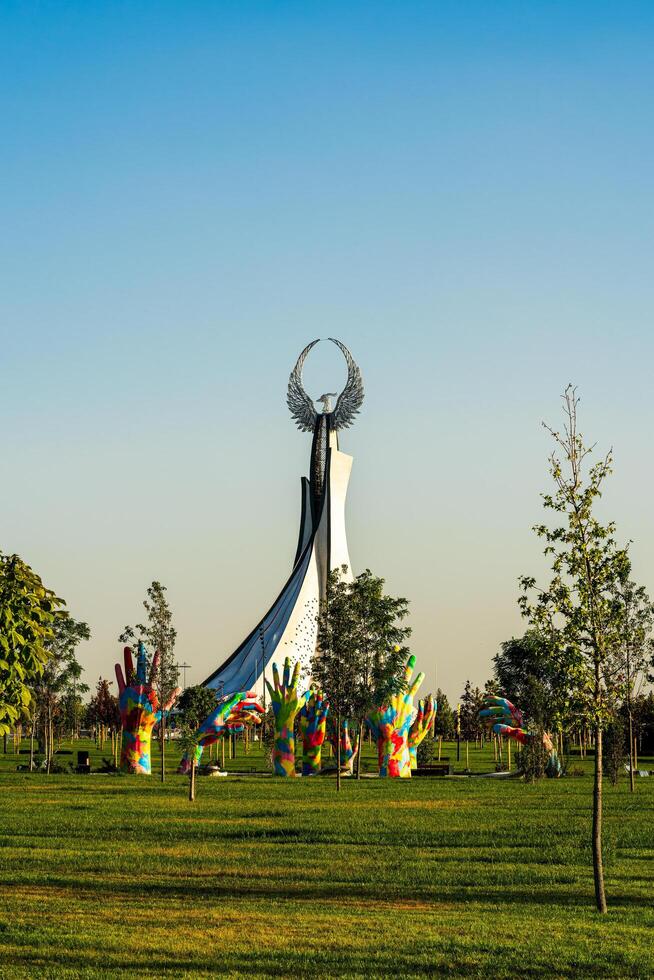 UZBEKISTAN, TASHKENT - SEPTEMBER 15, 2023 Monument of Independence in the form of a stele with a Humo bird on a daytime in the New Uzbekistan park in summer. photo