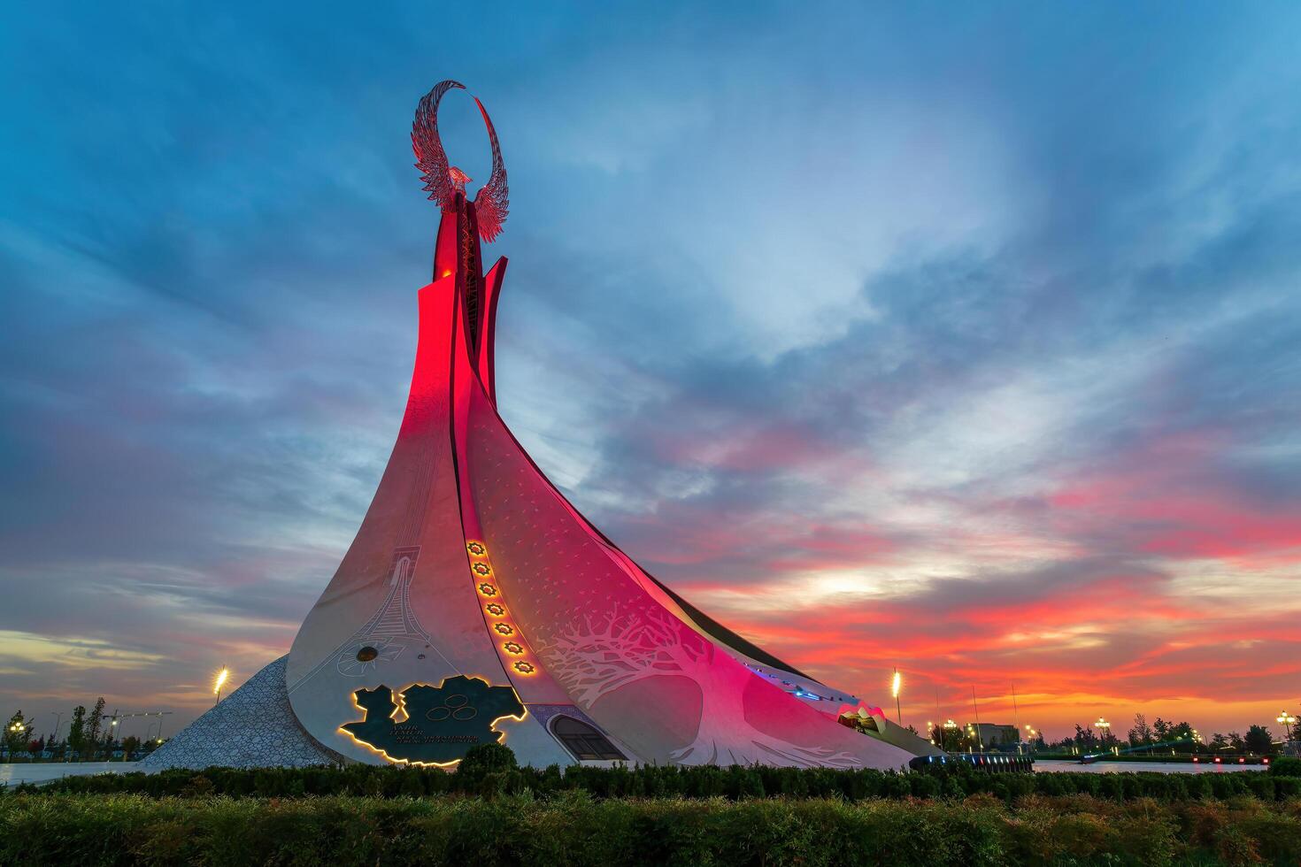 UZBEKISTAN, TASHKENT - SEPTEMBER 15, 2023 Monument of Independence in the form of a stele with a Humo bird on a twilight with dramatic cliods in the New Uzbekistan park. photo