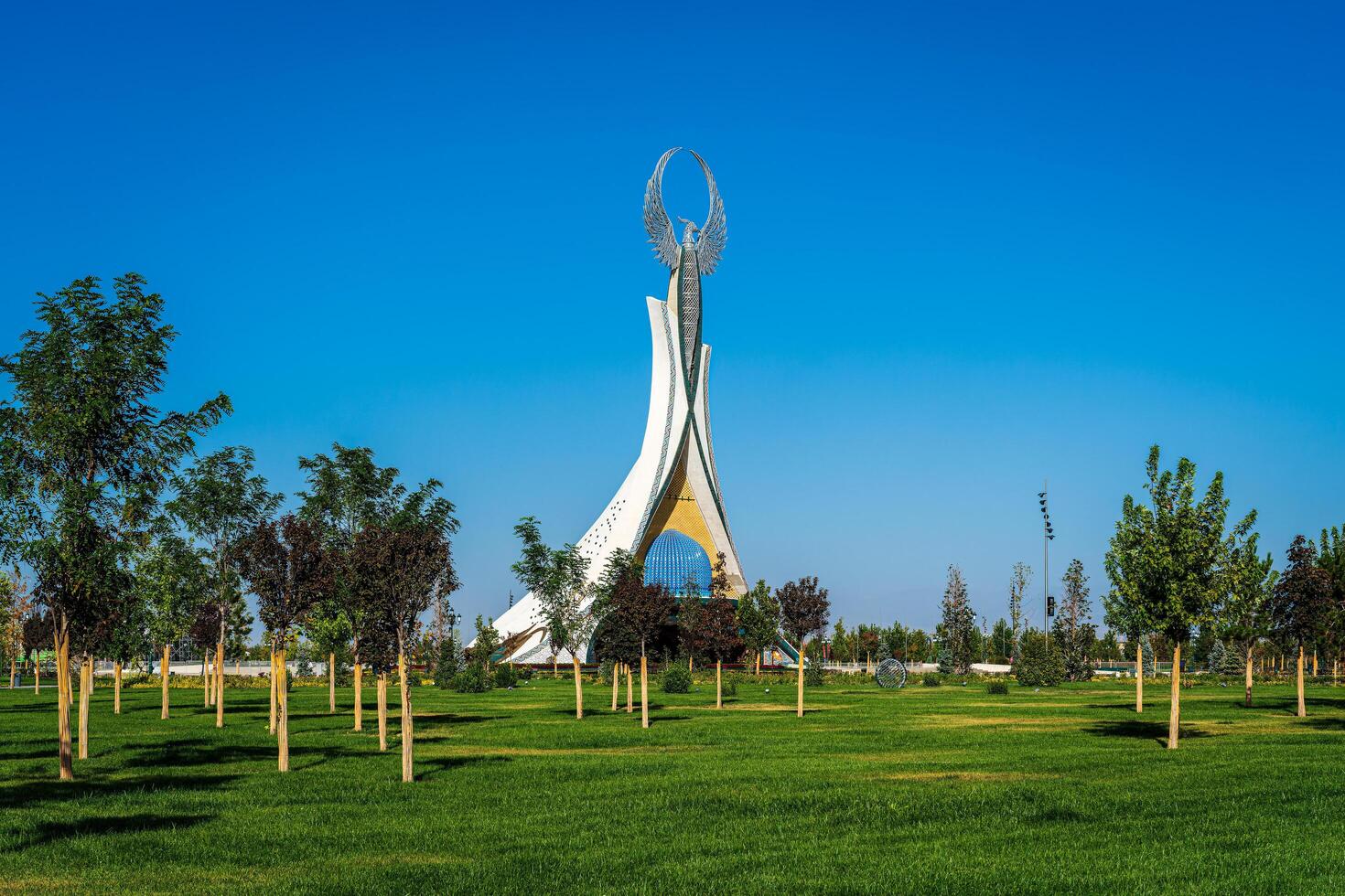 UZBEKISTAN, TASHKENT - SEPTEMBER 15, 2023 Monument of Independence in the form of a stele with a Humo bird on a daytime in the New Uzbekistan park in summer. photo