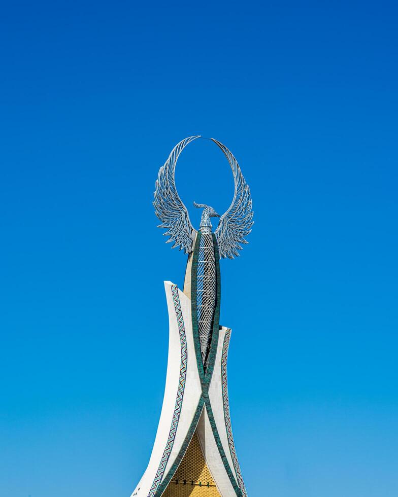 UZBEKISTAN, TASHKENT - SEPTEMBER 15, 2023 Monument of Independence in the form of a stele with a Humo bird on a daytime in the New Uzbekistan park in summer. photo