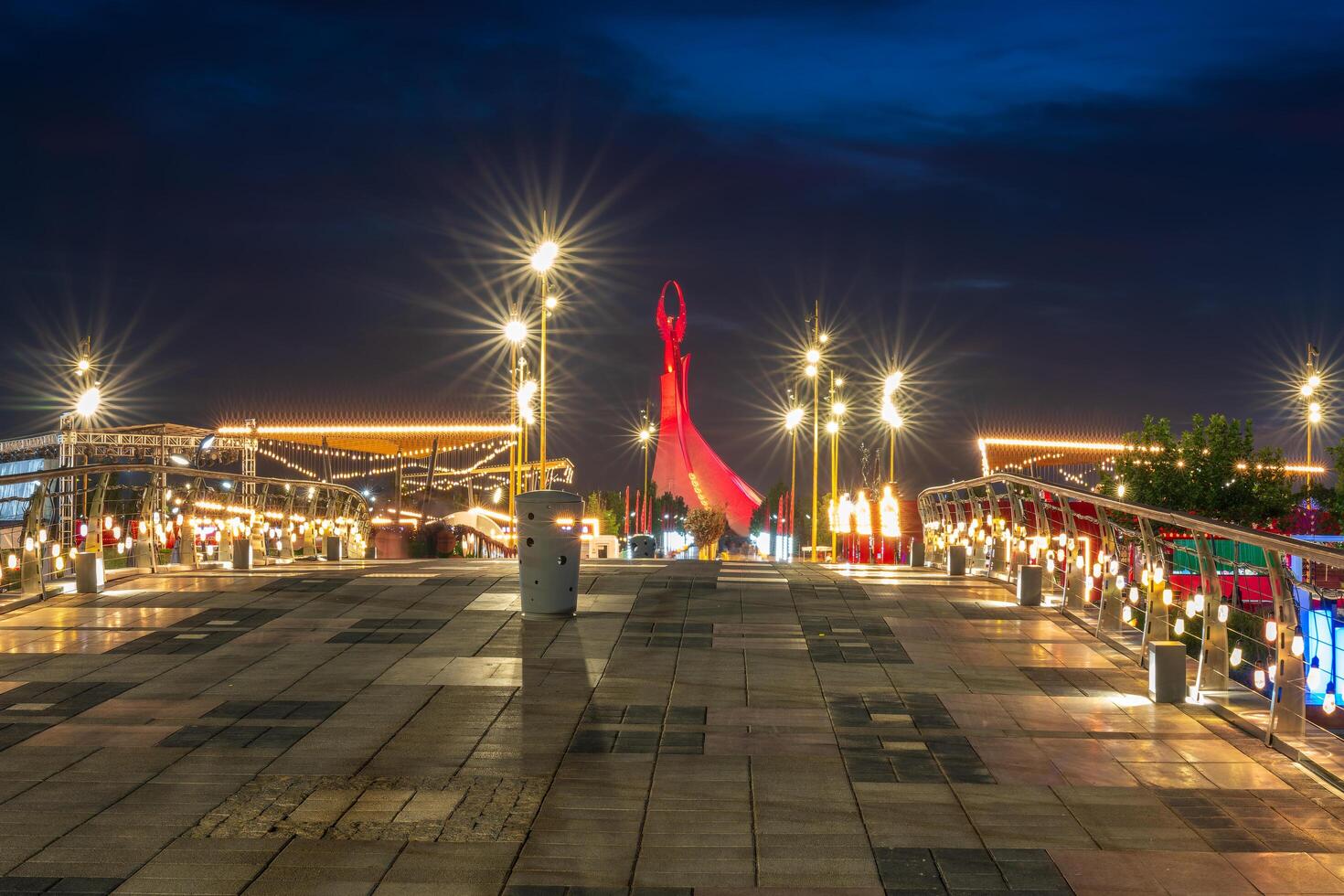 UZBEKISTAN, TASHKENT - SEPTEMBER 15, 2023 Illuminated monument of independence in the form of a stele with a Humo bird in the New Uzbekistan park at nighttime in autumn. photo