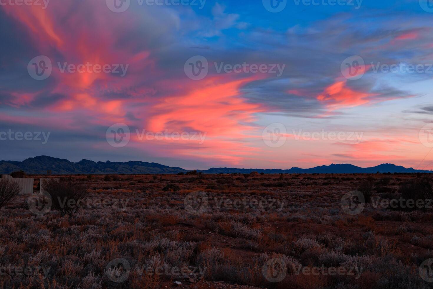 Crimson Sky Over Desert Terrain photo