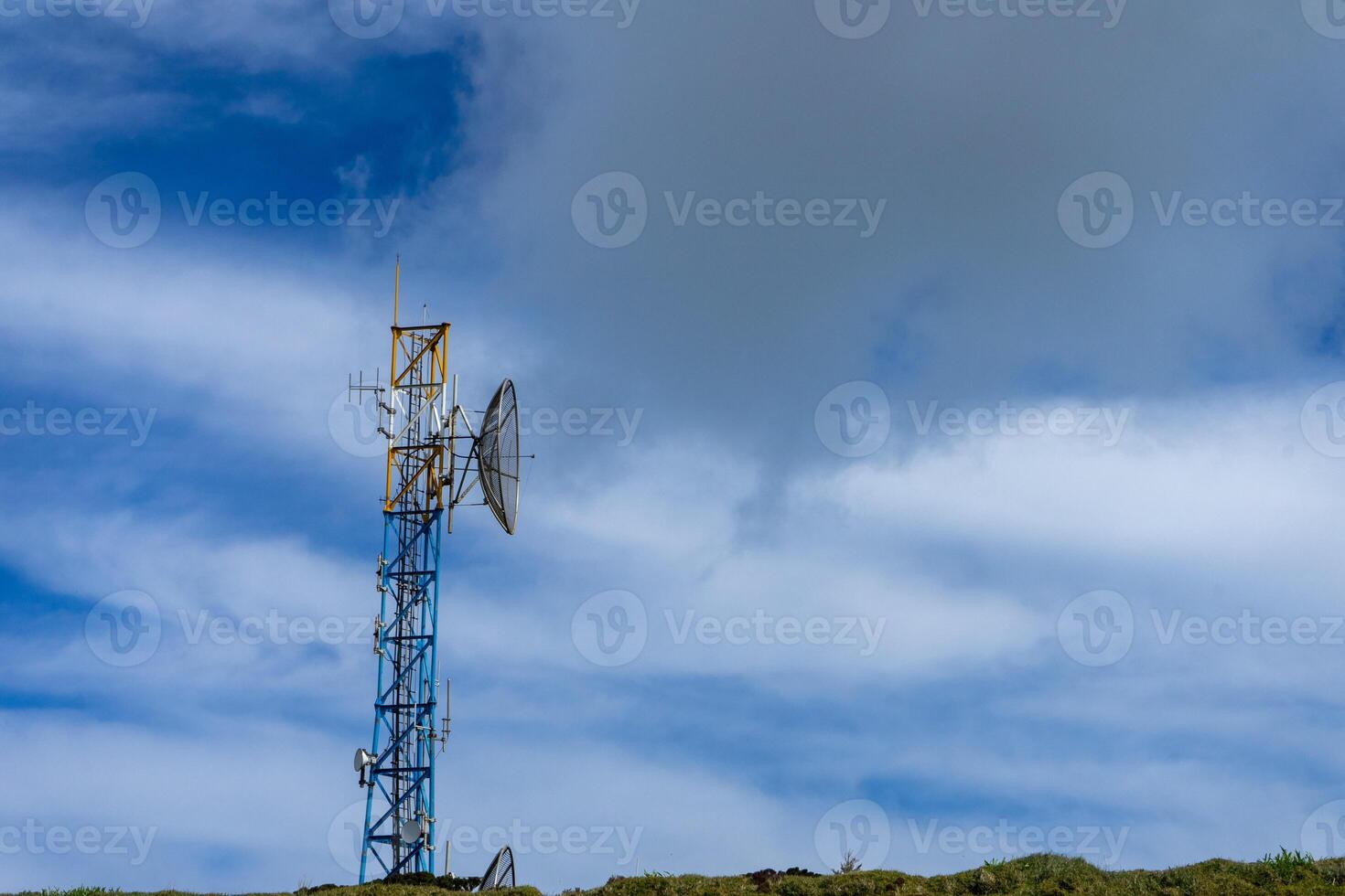 moderno telecomunicaciones torre soportes alto en contra dramático montaña fondo en serra hacer cum, terceira isla, azores. un símbolo de conectividad en remoto belleza. foto