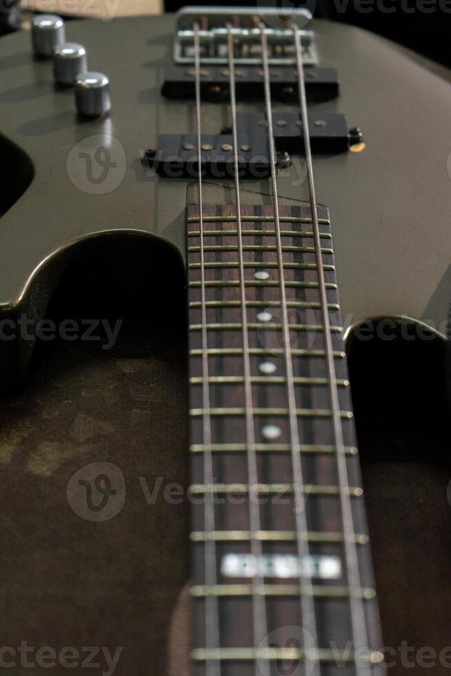 A close-up shot of bass guitar strings showcasing their texture and alignment. The image emphasizes the metallic sheen of the wound strings, with a focus on the subtle details and fine craftsmanship. photo