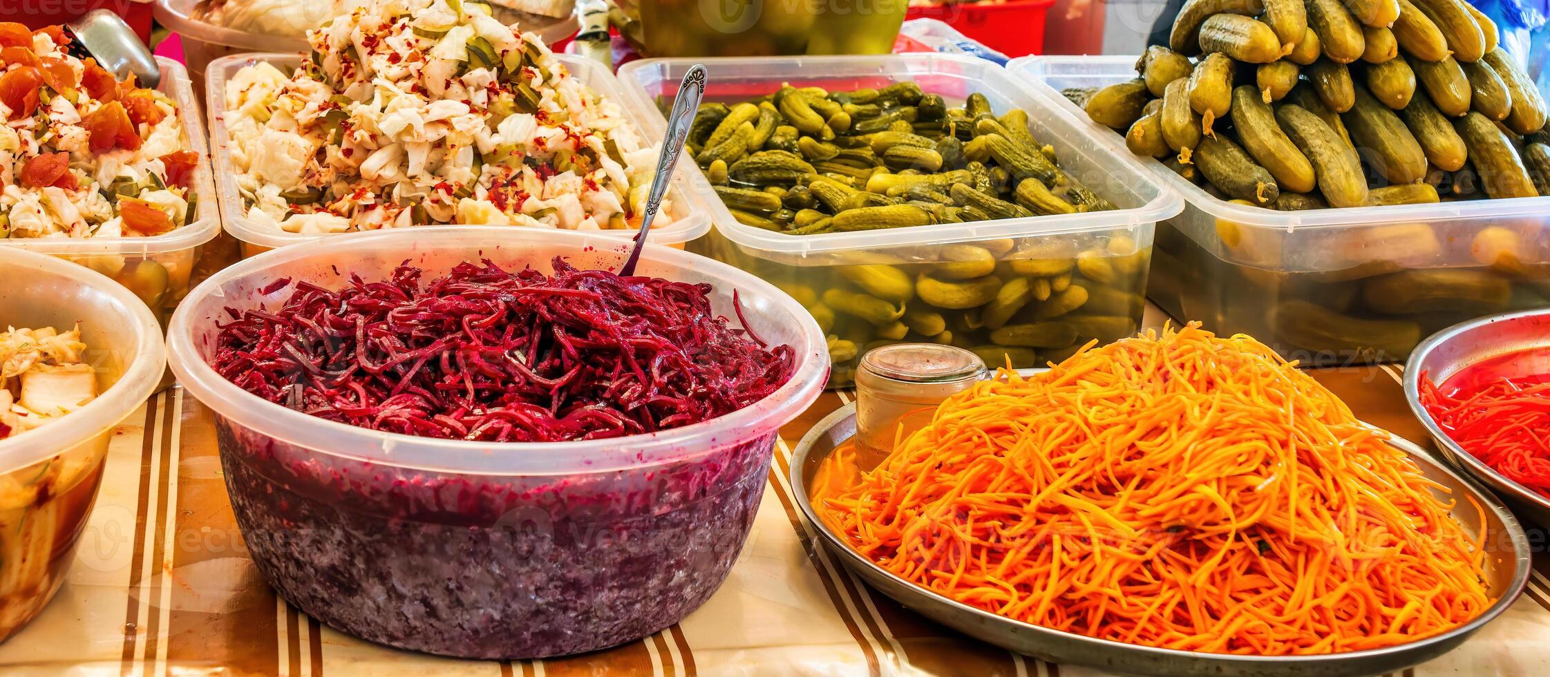A stall with pickled vegetables at a bazaar counter. Pickled beets, cucumbers, sauerkraut, Korean-style carrots and cucumbers. photo