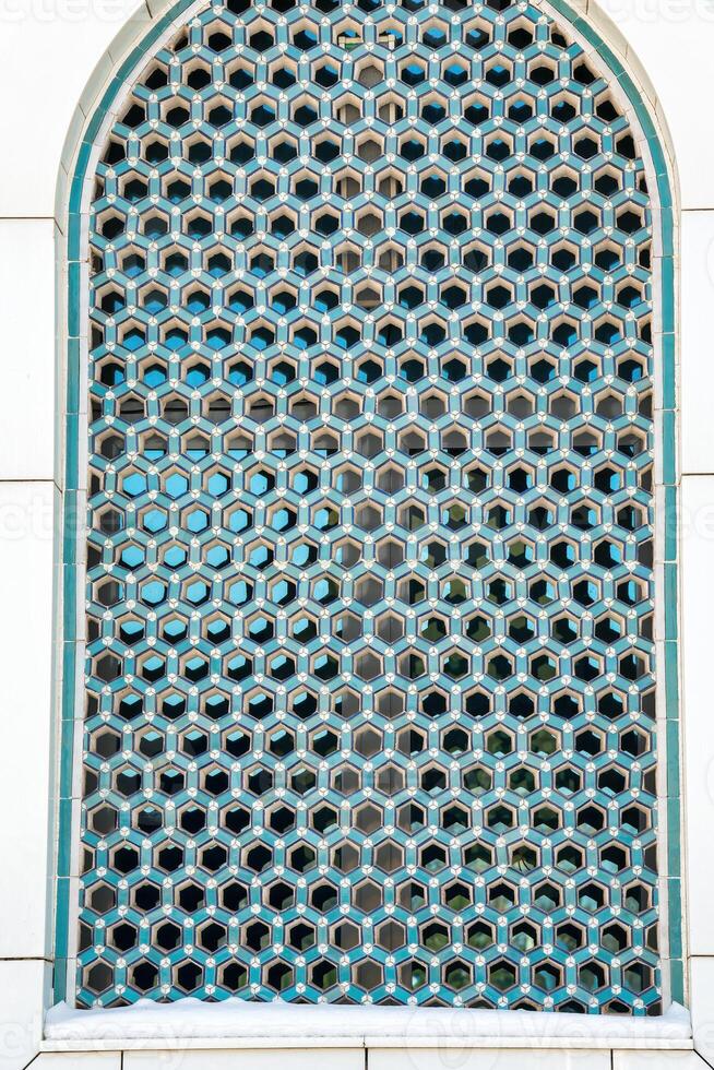 el ventana de un musulmán mezquita detrás barras en el formar de un geométrico hexagonal islámico ornamento. foto