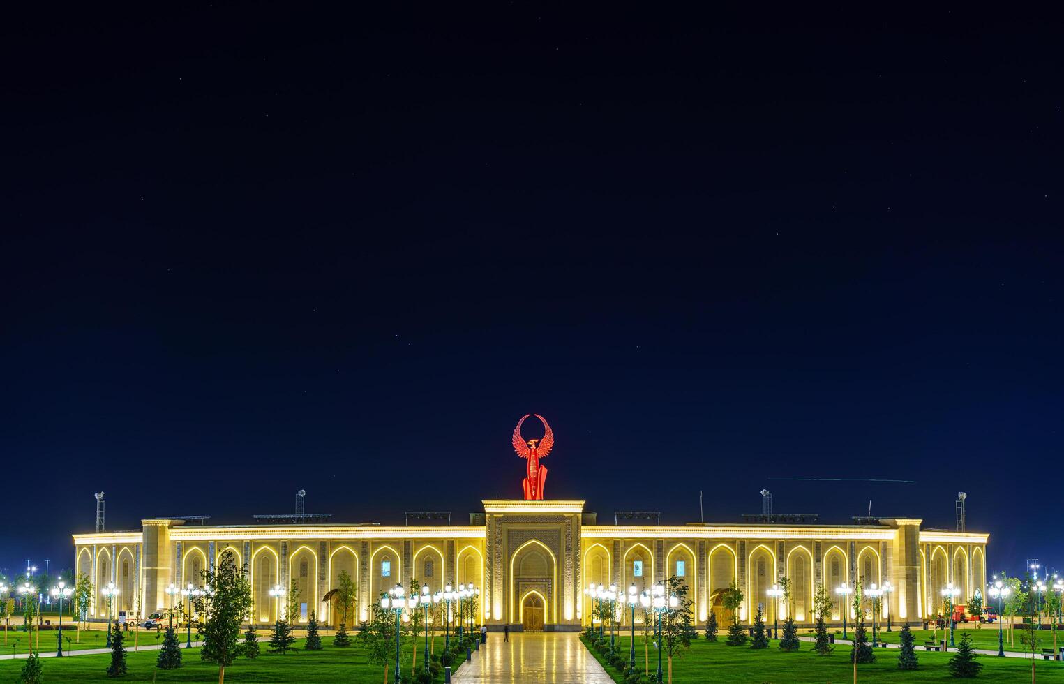 Uzbekistan, Tashkent - September 1, 2023 The territory of the park New Uzbekistan with Monument of Independence in the form of a stele with a Humo bird at night. photo
