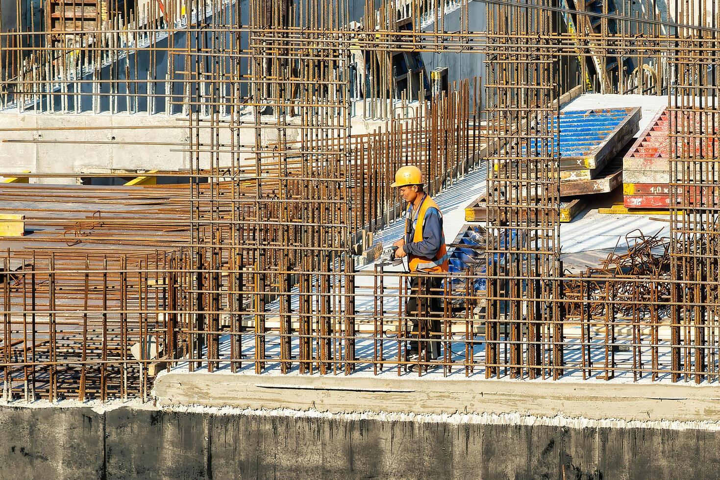 RUSSIA, KALUGA - AUGUST 15, 2022 Workers assembling the frame of a building from rebar. photo