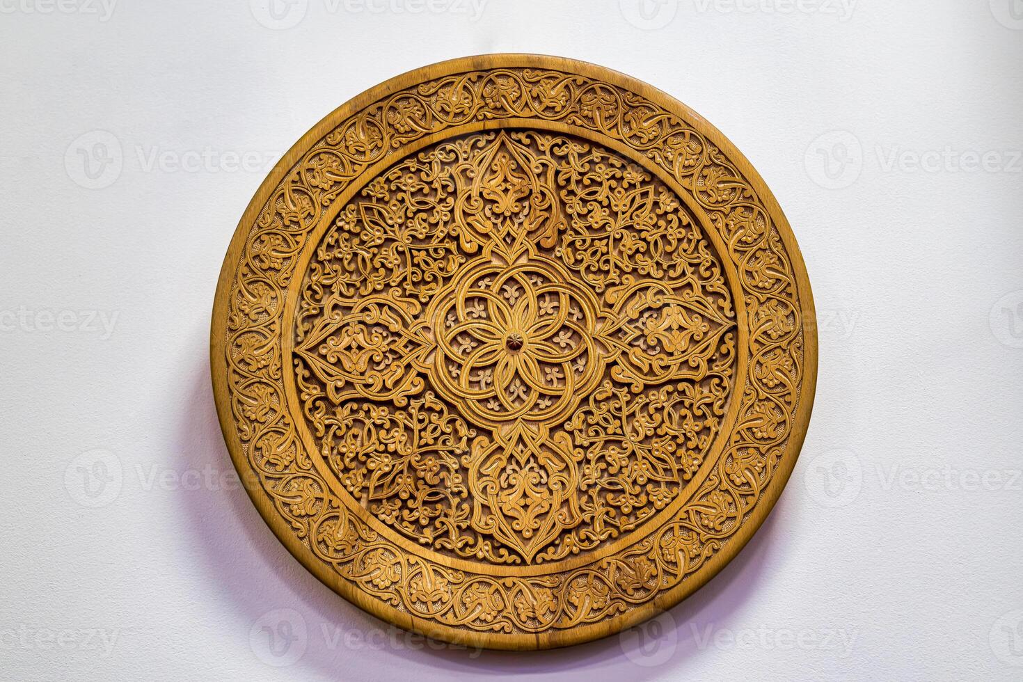 Fragment of an ancient carved wooden round plate. Ornate. photo