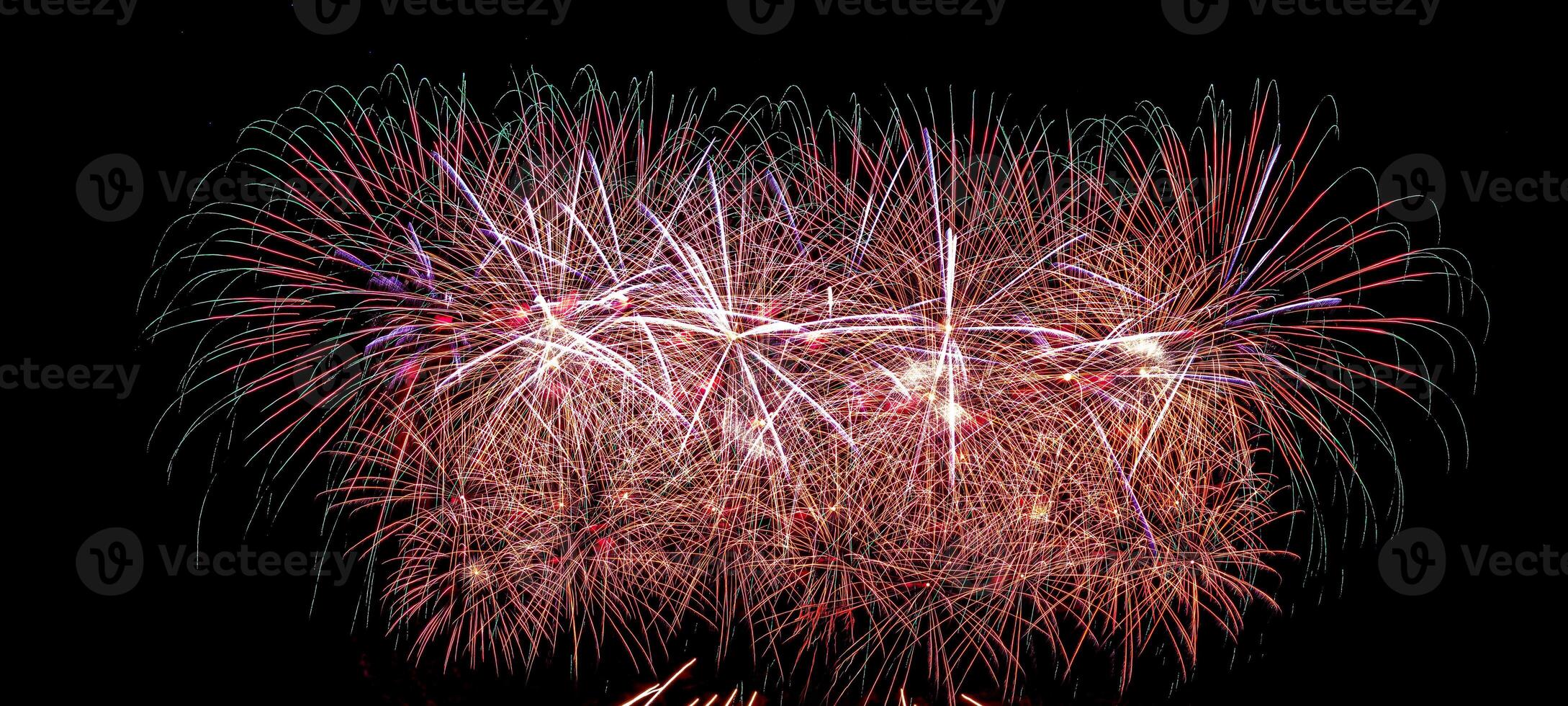 Colorful celebration fireworks isolated on a black sky background. photo