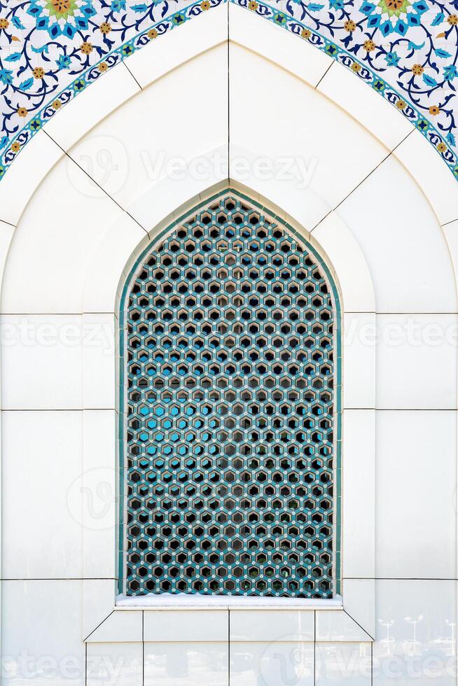 The window of a Muslim mosque behind bars in the form of a geometric hexagonal Islamic ornament. photo