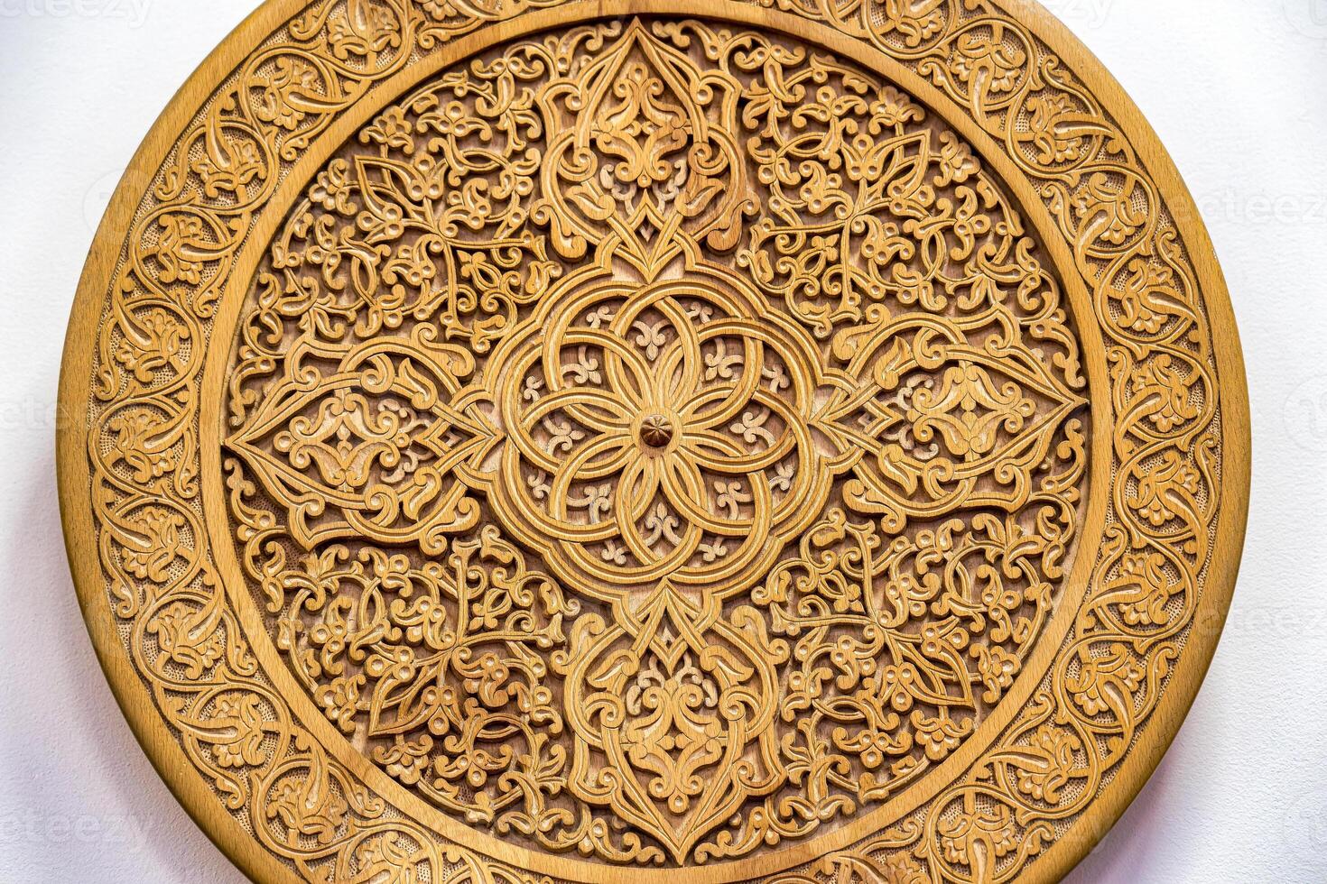 Fragment of an ancient carved wooden round plate. Ornate. photo