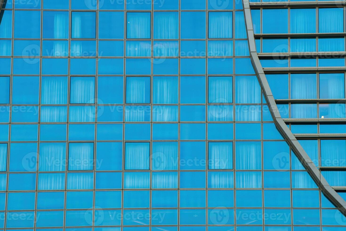 Fragment of a modern office building. Abstract geometric background. Part of a skyscraper with glass windows. photo
