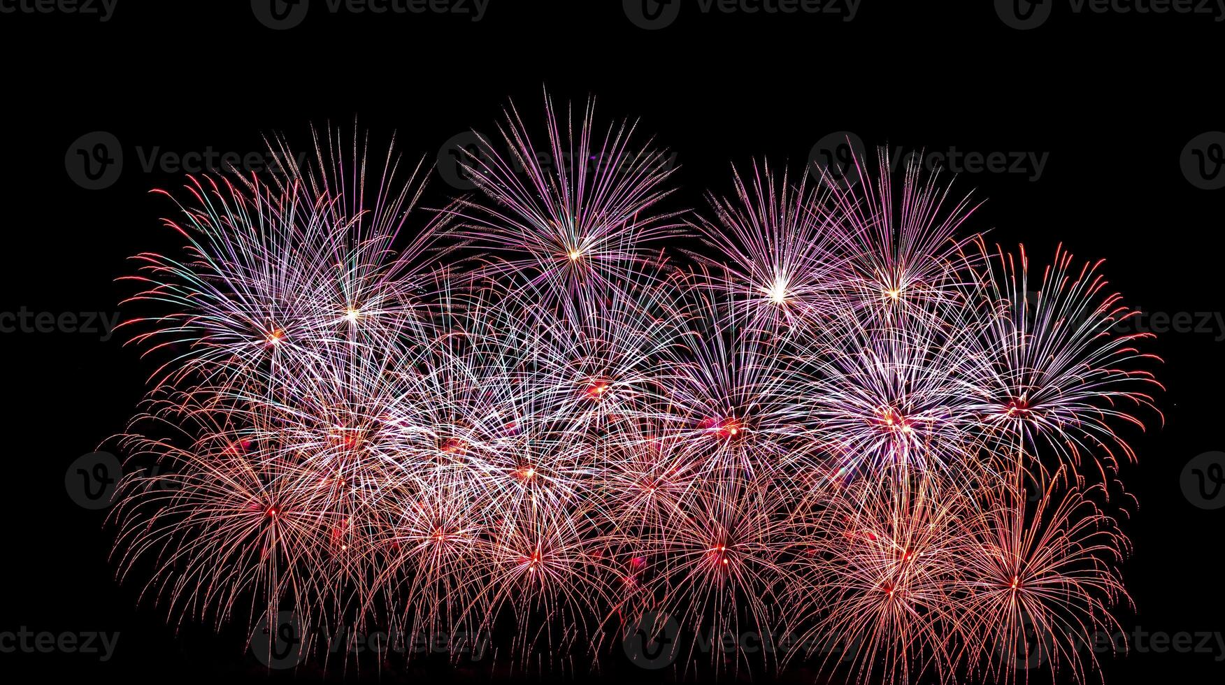 Colorful celebration fireworks isolated on a black sky background. photo