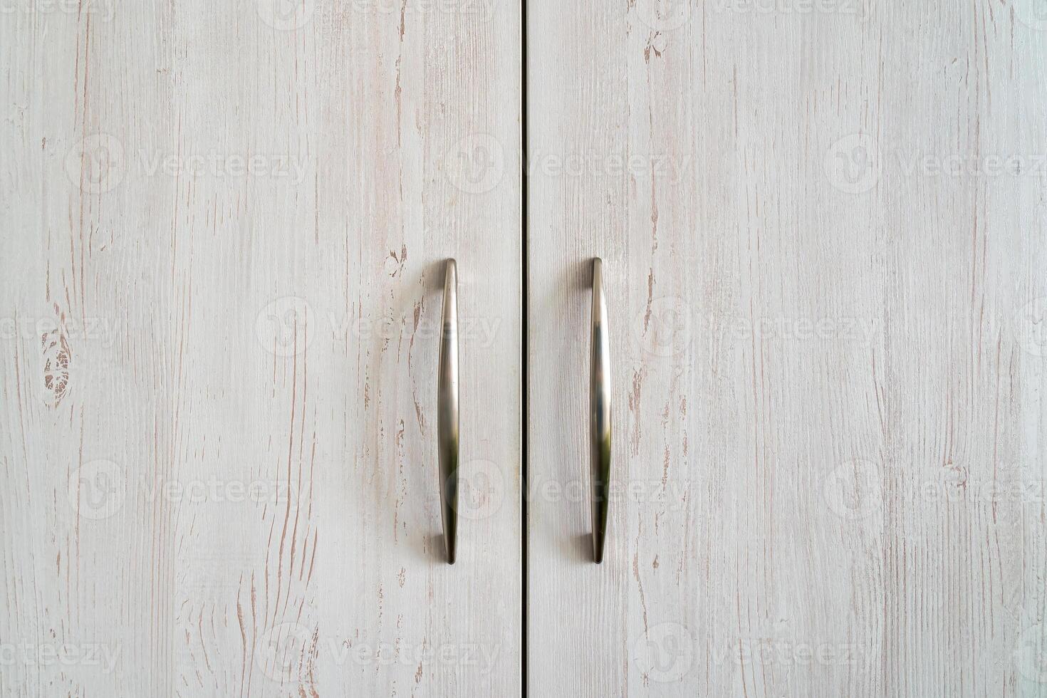 Closed cabinet doors in wood with metal handles. photo