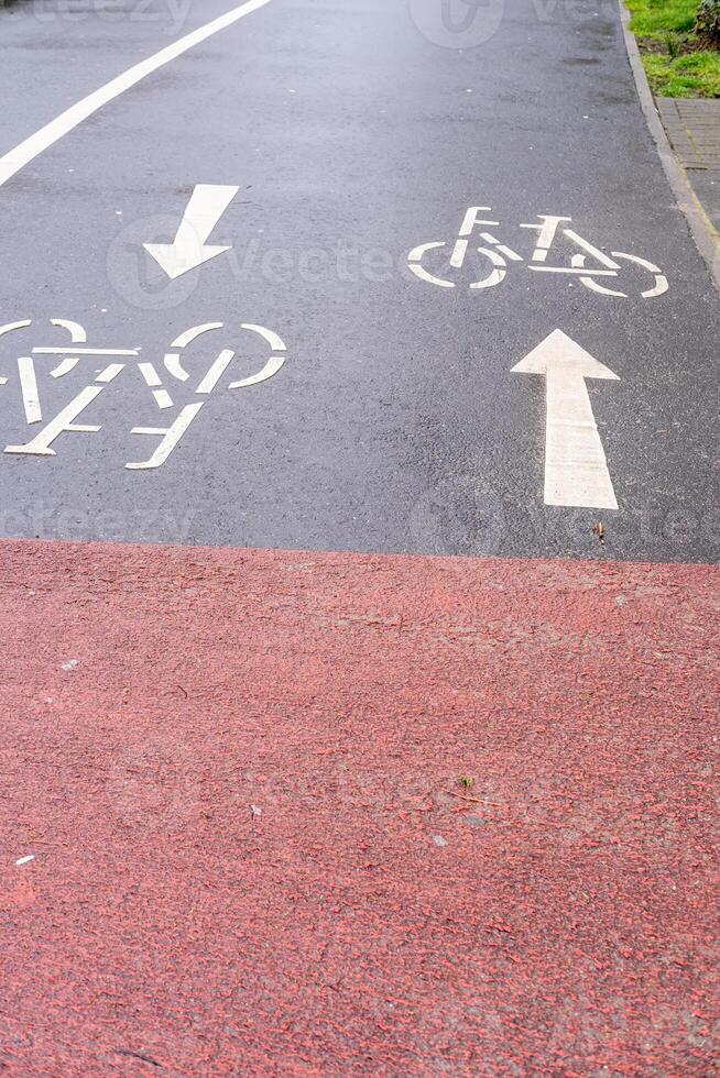 wet road with cycle path sign photo