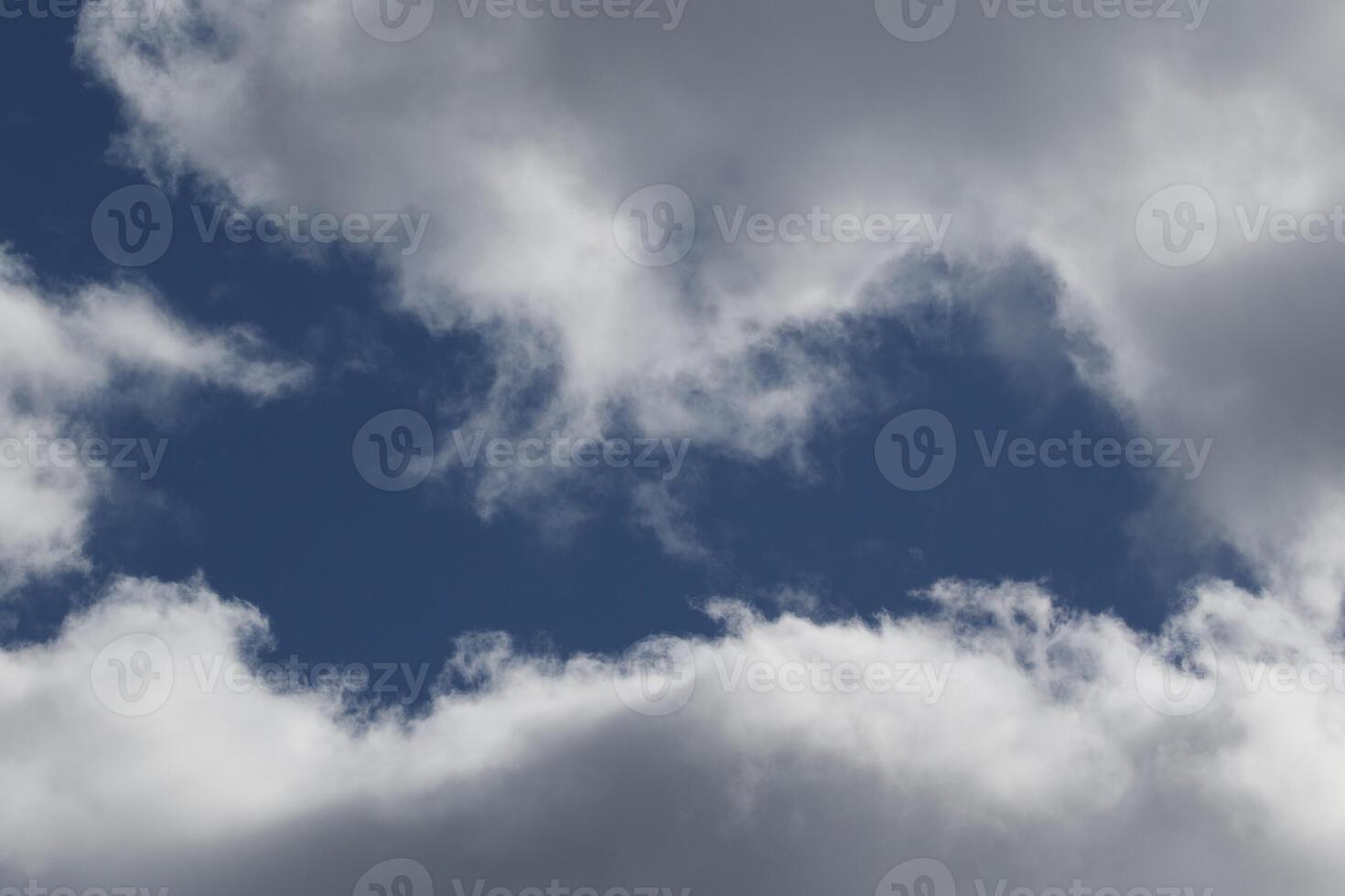 Cloudscape scenery, overcast weather above dark blue sky. Storm clouds floating in a rainy dull day with natural light. White and grey scenic environment background. Nature view. photo
